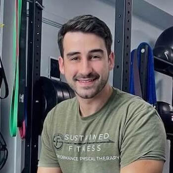 a man in a green shirt smiling in front of a gym.