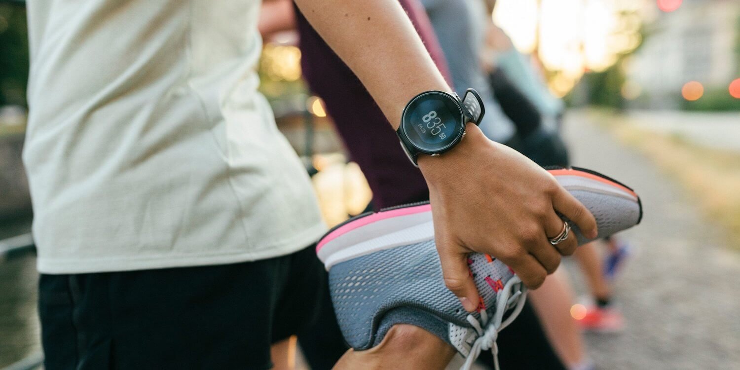 a group of people holding a watch and a pair of running shoes.