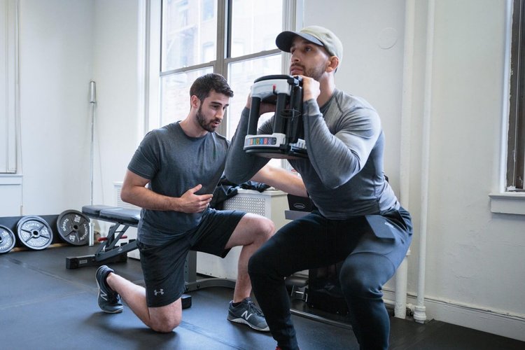 two men working out in a gym.