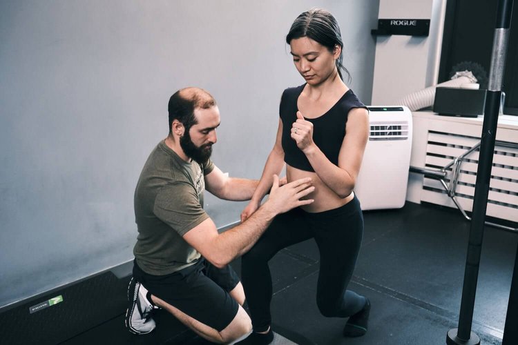 a man is helping a woman in a gym.