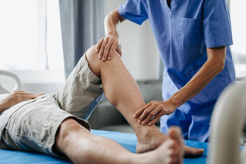 Physical therapist performing manual knee assessment to support faster torn ACL recovery time and rehabilitation progress.