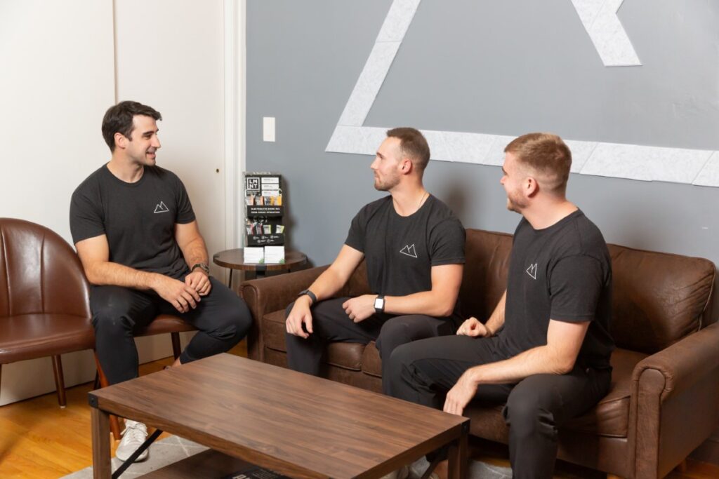 Team members from Sustain Physical Therapy and Performance having a collaborative discussion in the clinic lounge.