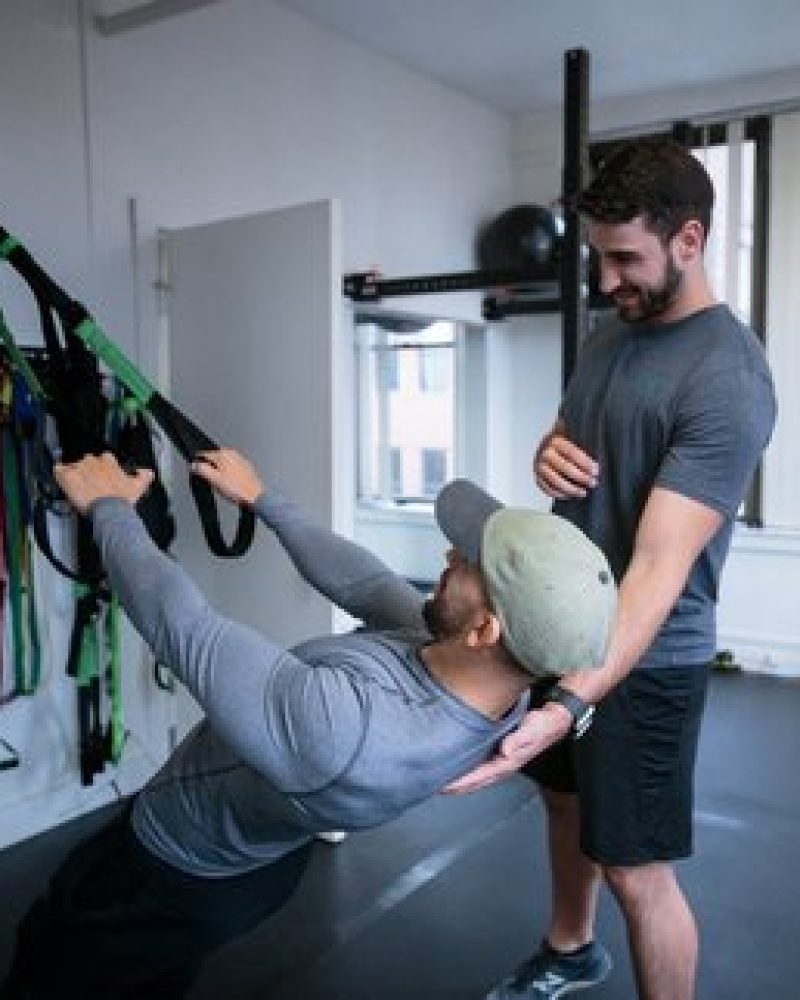 a man is doing a trx workout in a gym.