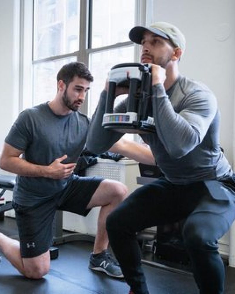 two men working out in a gym.