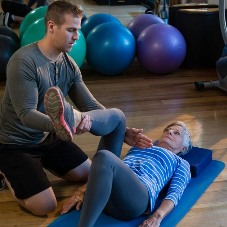 male-physiotherapist-helping-patient-in-performing-2023